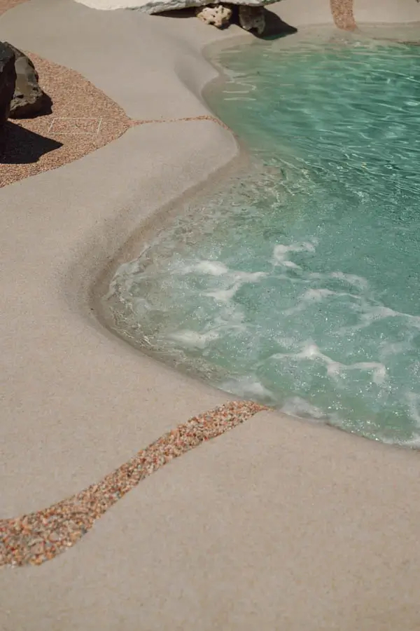 Close-up of a soft sand edge meeting clear, gently rippling water