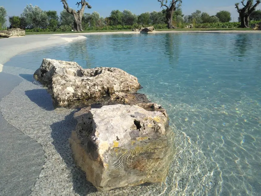 Weathered limestone boulder set into clear shallow water